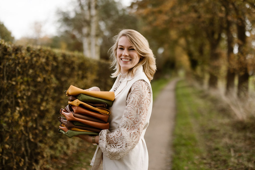 Jolien met een stapeltje Huck tassen. Haar missie: eerlijke en duurzame mode toegankelijk maken!